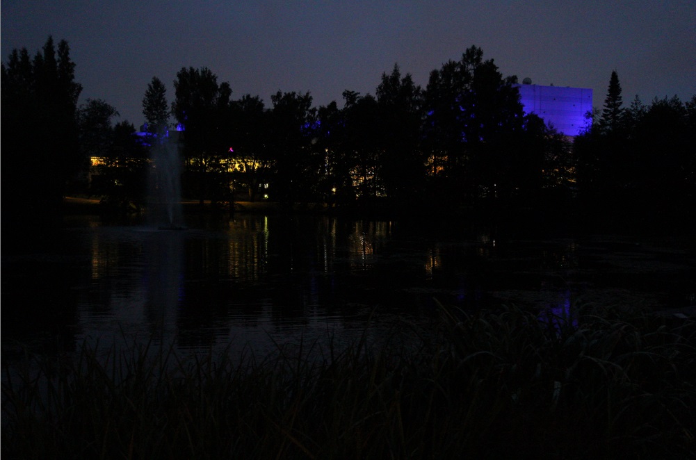 Kuvassa öinen Tampere-talo kuvattuna Sorsapuiston lammelta